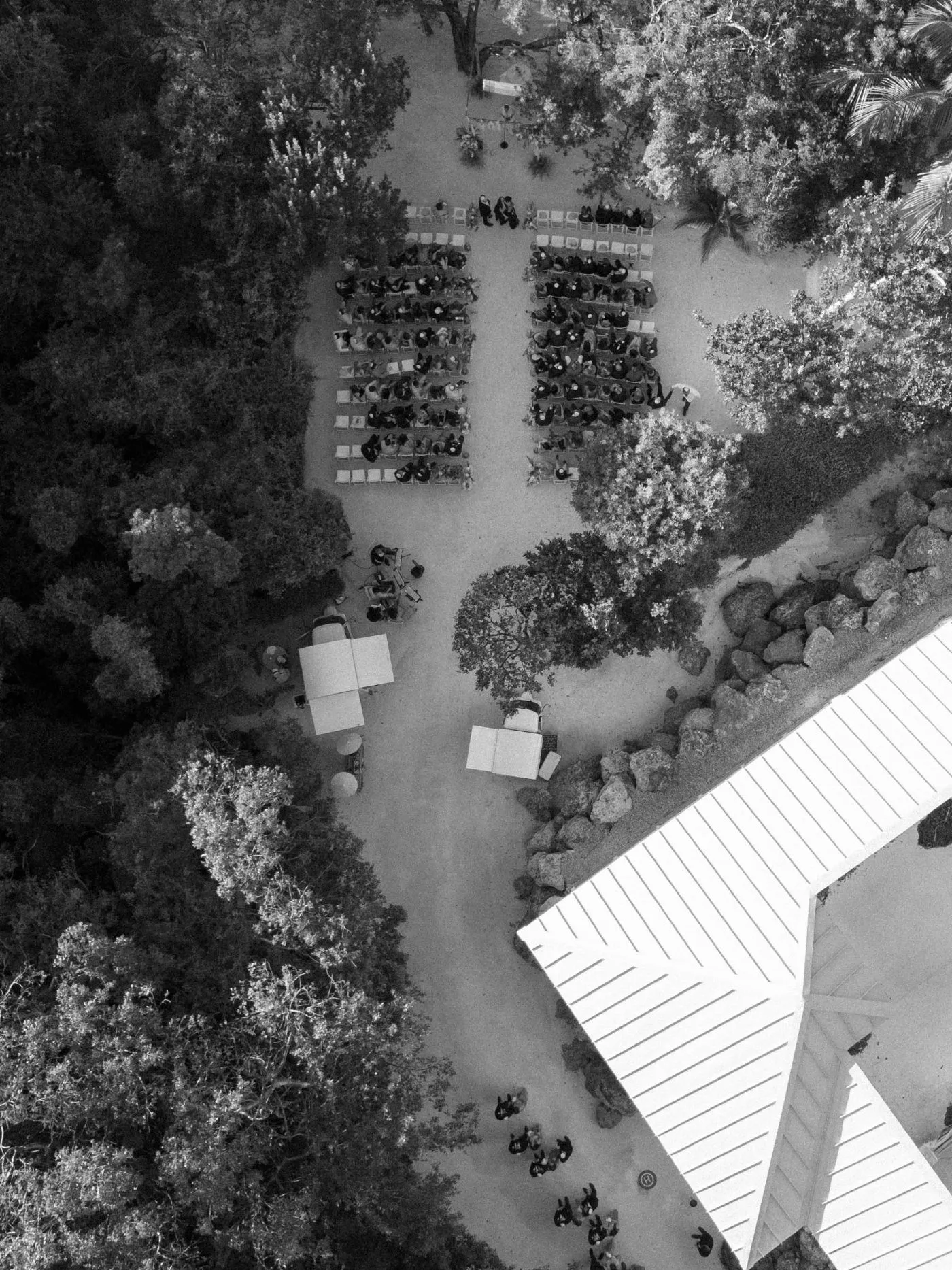 Aerial view of guests seated in rows for an outdoor ceremony among trees