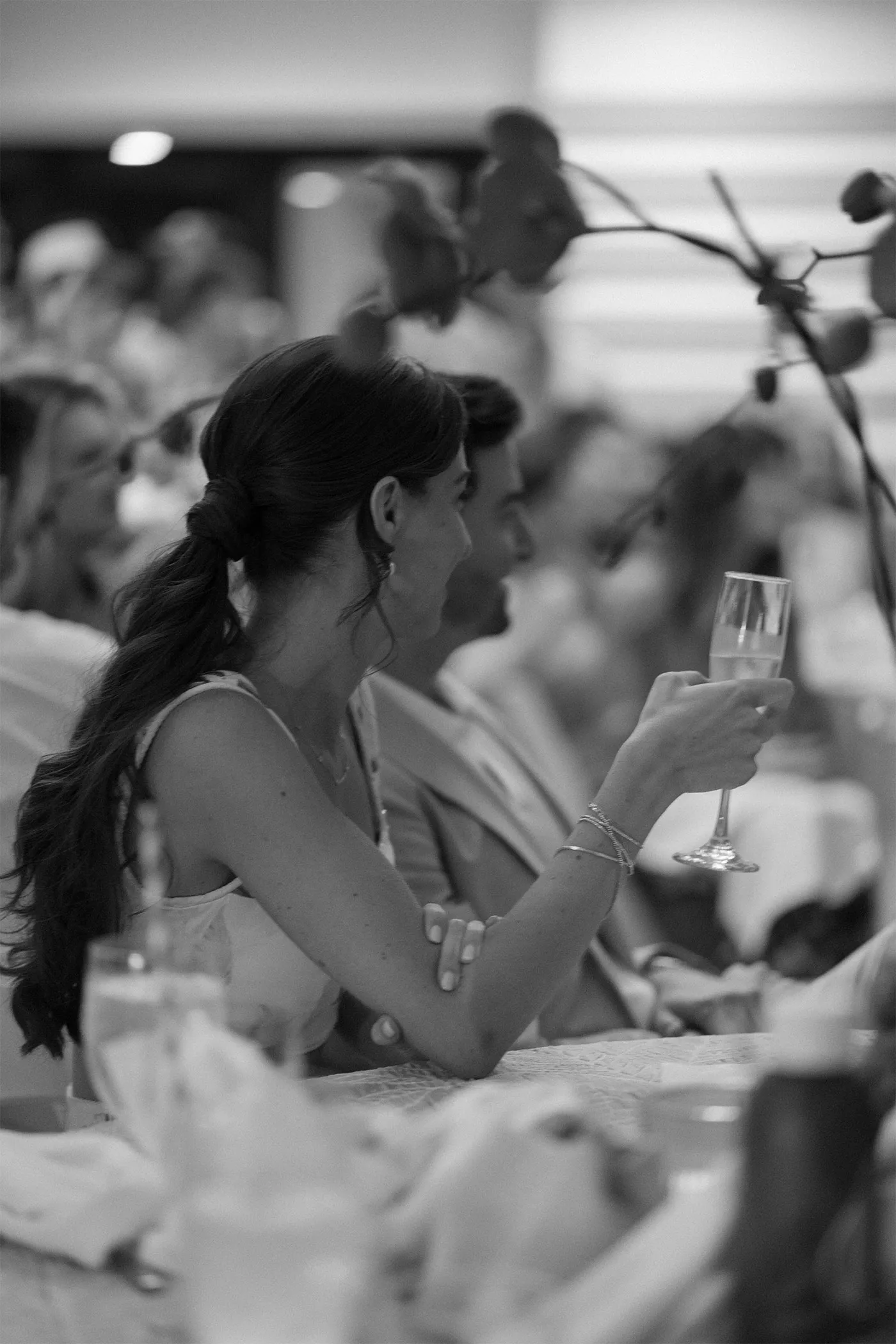 Guest raising a champagne flute at a candlelit reception table