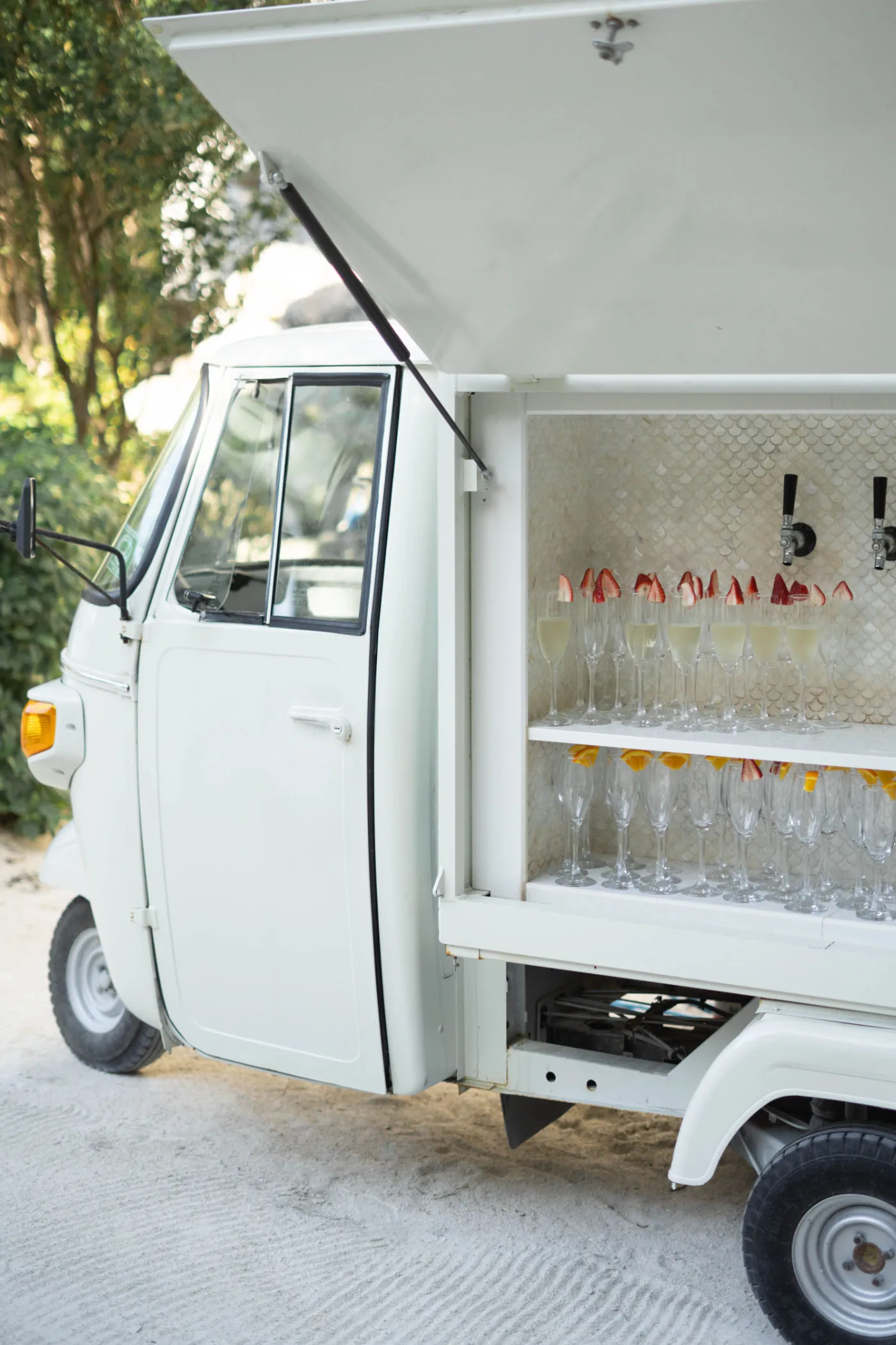 Vintage three-wheeled truck bar serving champagne flutes garnished with strawberries