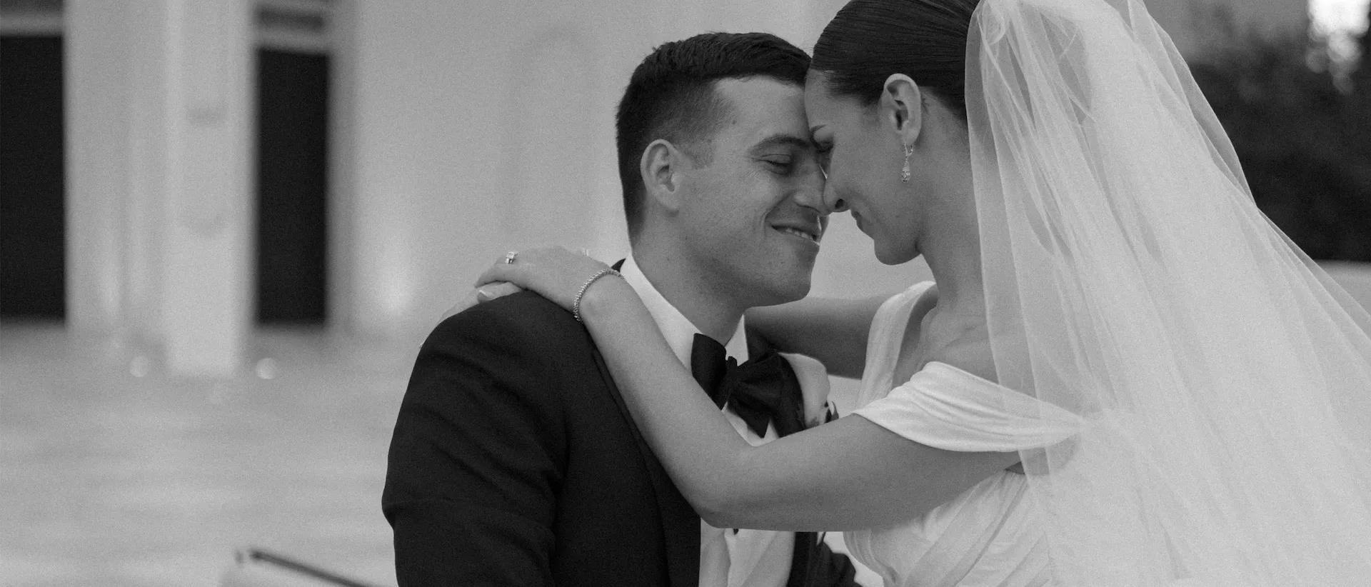 Bride and groom resting forehead to forehead, her arm around his shoulder