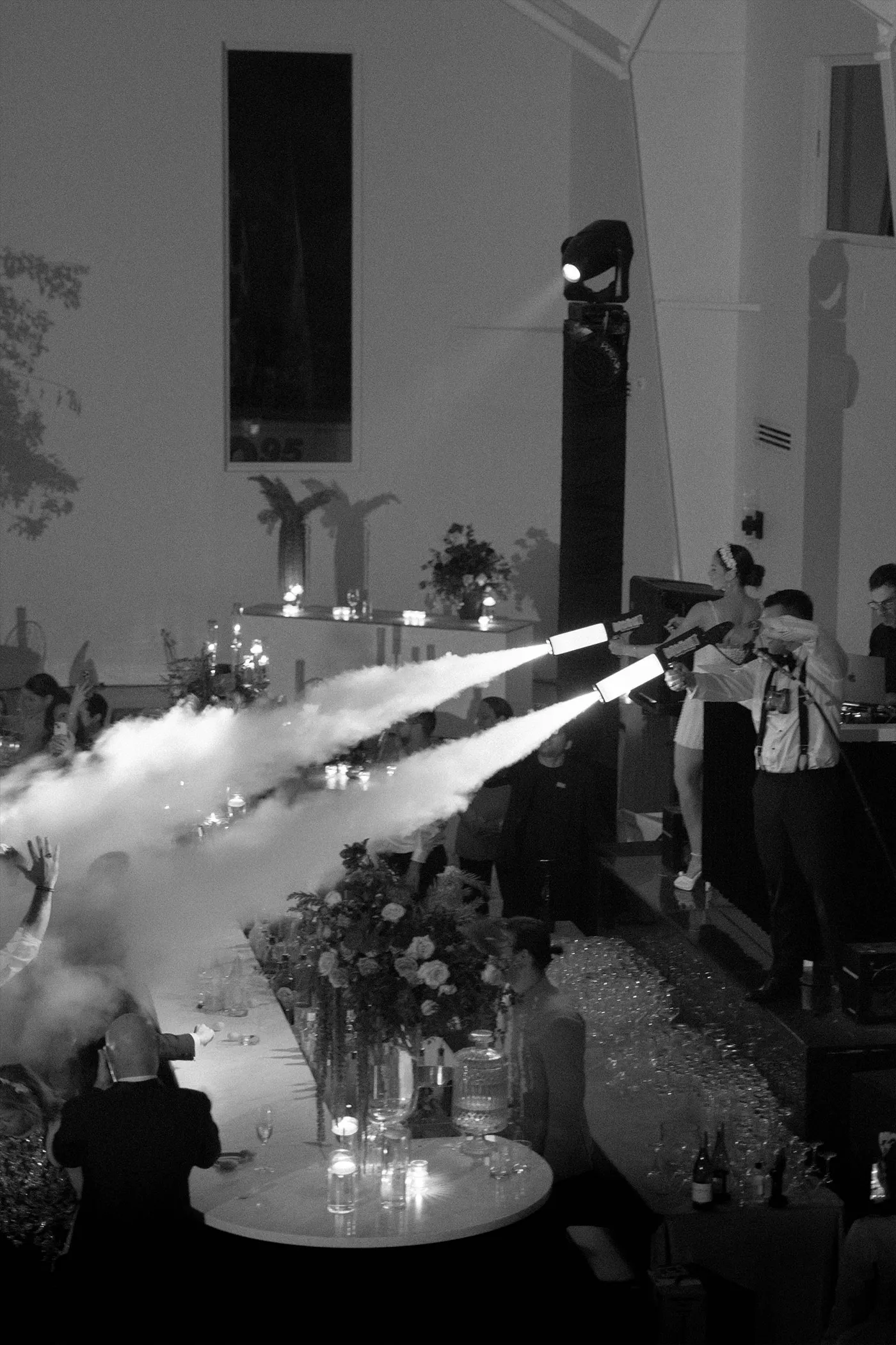 CO2 jets firing over a long dinner table as guests react at a night reception
