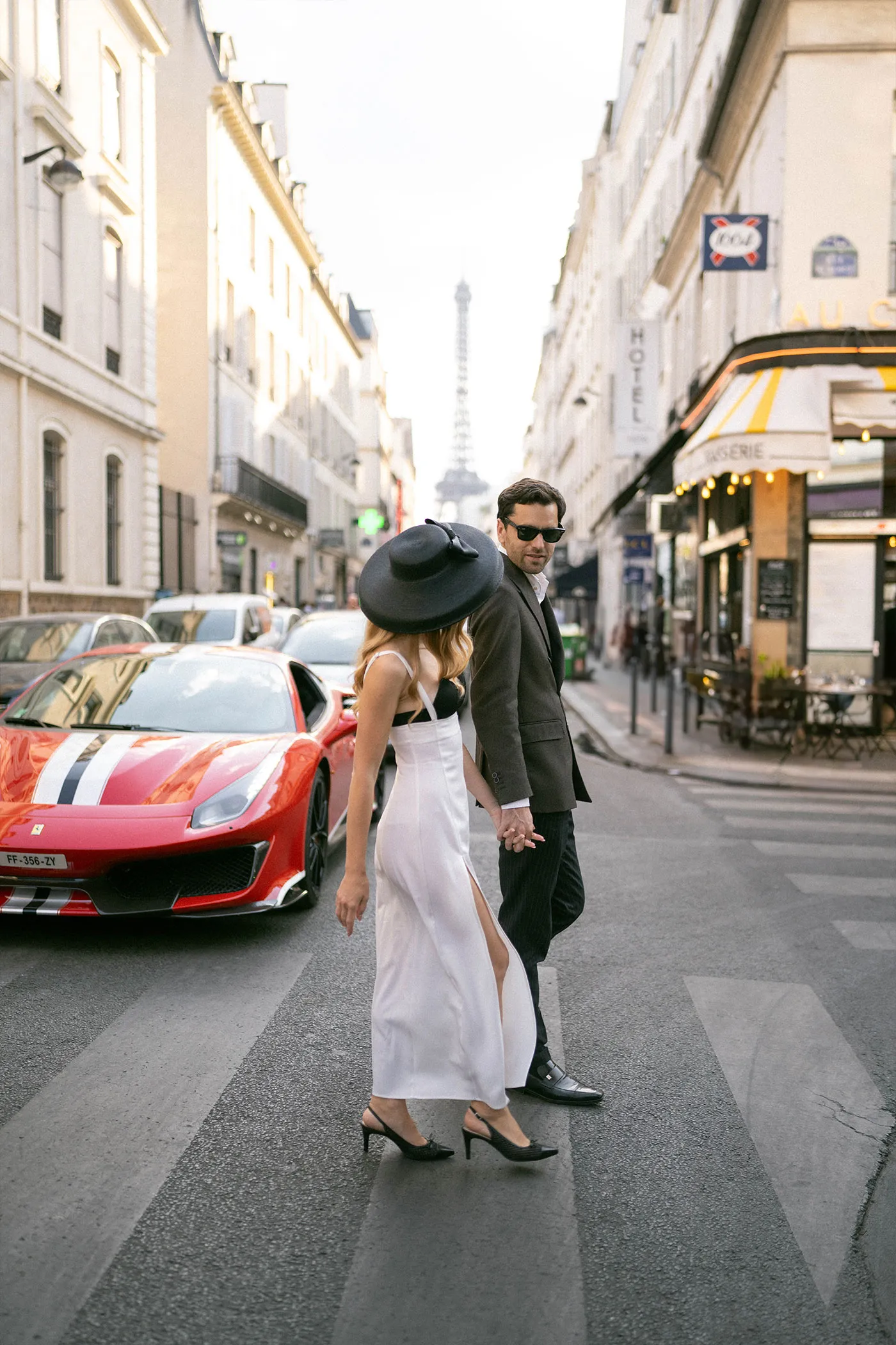 Couple crossing a Paris street with the Eiffel Tower in the distance
