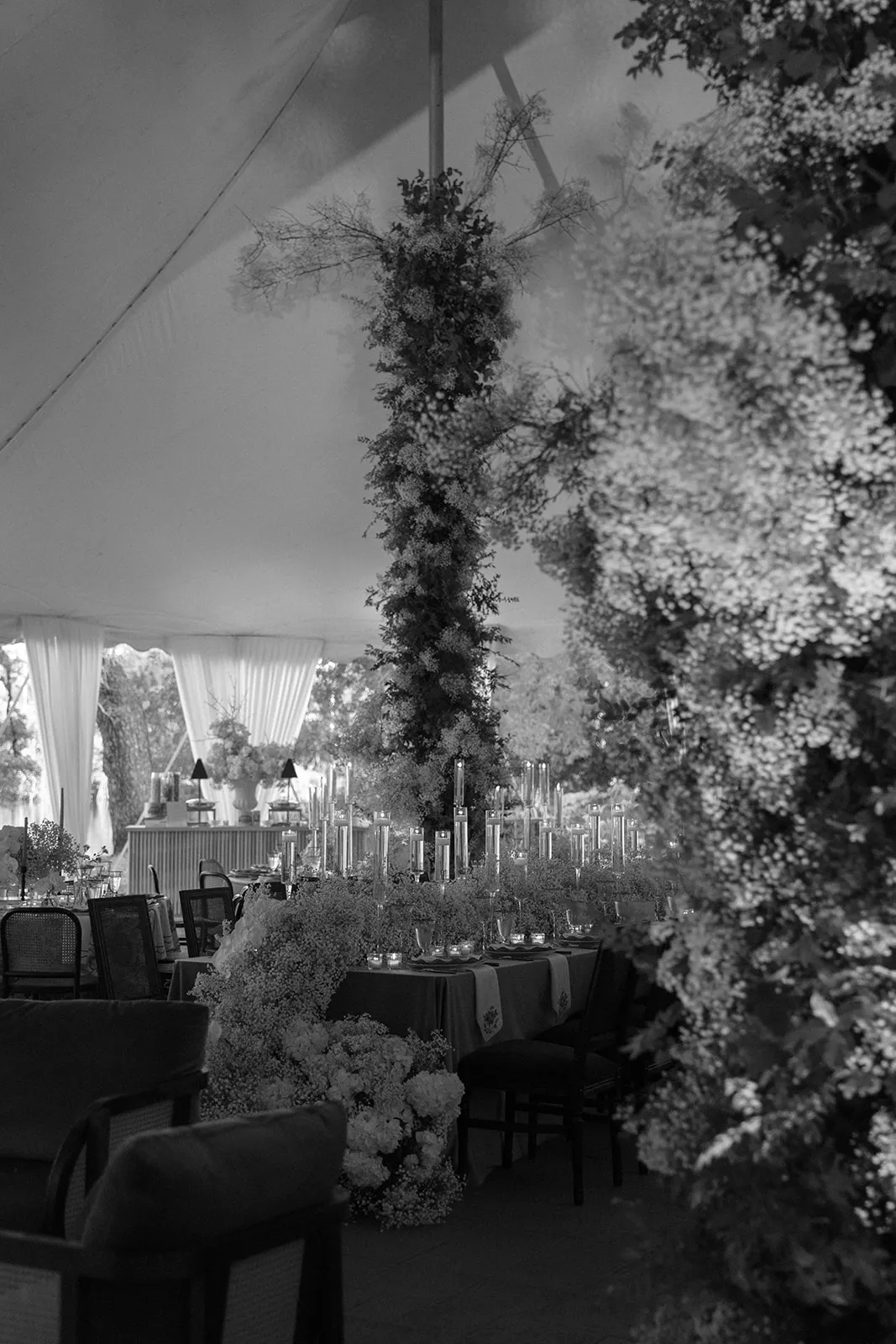 Tented reception with tall tapers and columns of blossom, in black and white